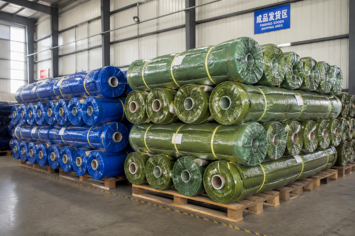 Stacks of industrial tarpaulin rolls in a warehouse ready for shipment